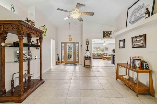 foyer entrance with light tile patterned floors, high vaulted ceiling, and ceiling fan