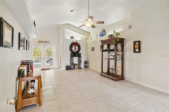 interior space with high vaulted ceiling, light tile patterned floors, ceiling fan, and french doors