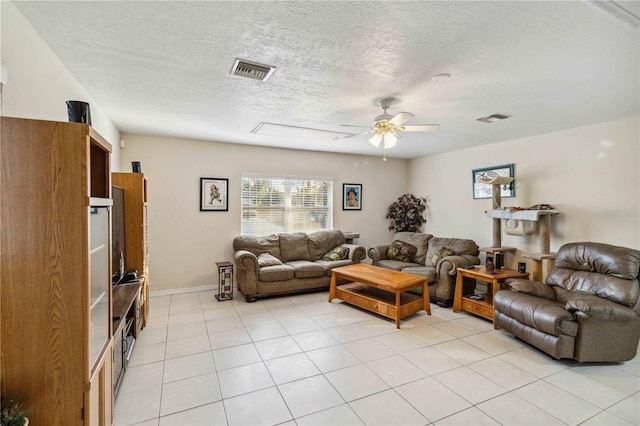 living room with ceiling fan, a textured ceiling, and light tile patterned floors