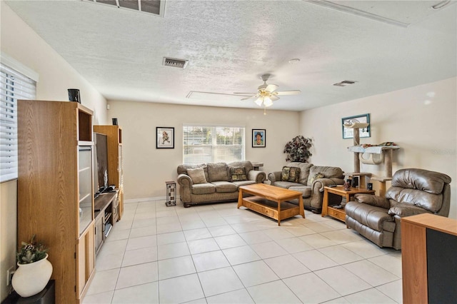 tiled living room with ceiling fan and a textured ceiling