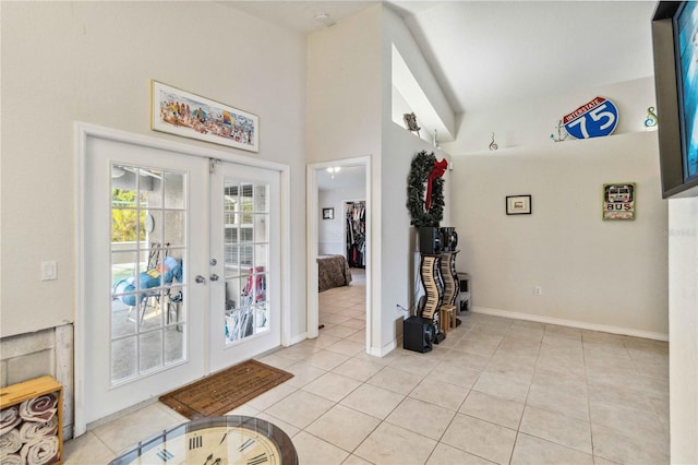 tiled foyer with french doors and a towering ceiling