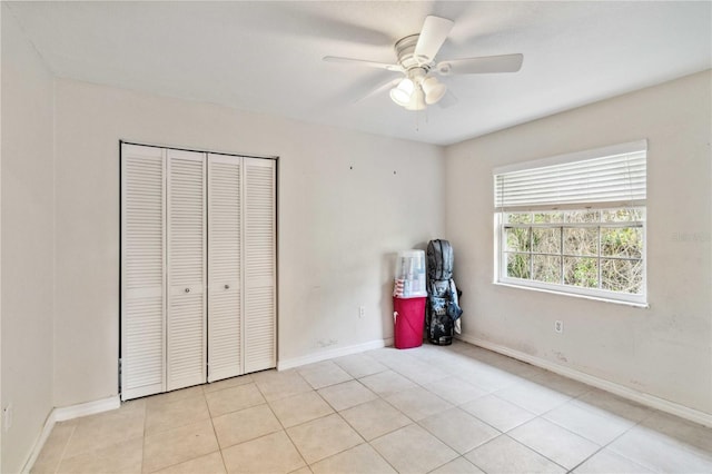 unfurnished bedroom featuring light tile patterned floors, ceiling fan, and a closet