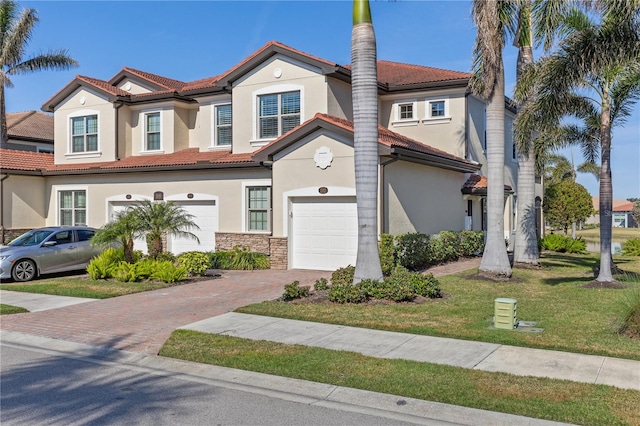 mediterranean / spanish house featuring a garage and a front yard