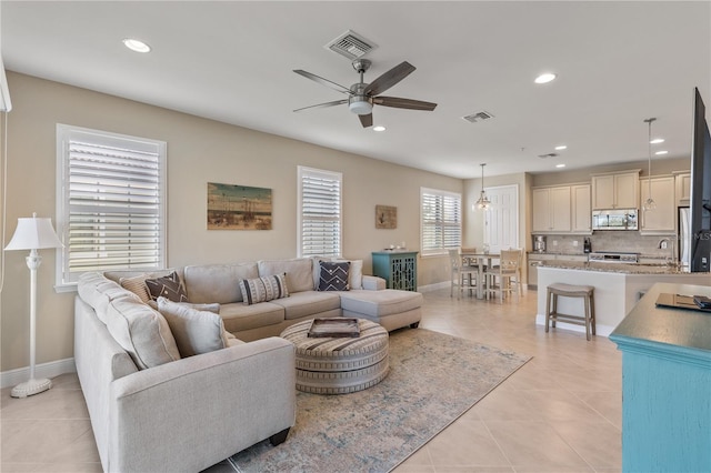 tiled living room featuring ceiling fan