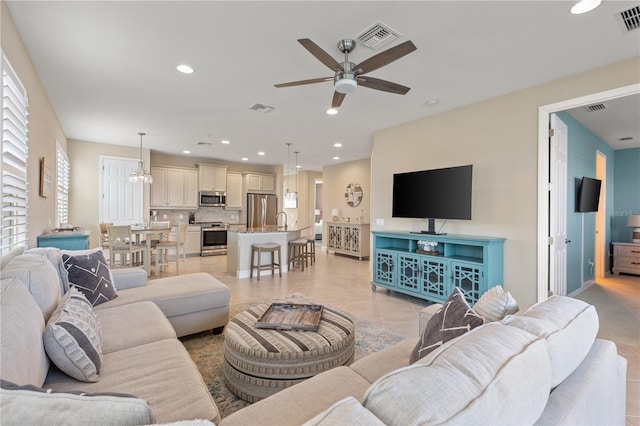 tiled living room featuring sink and ceiling fan