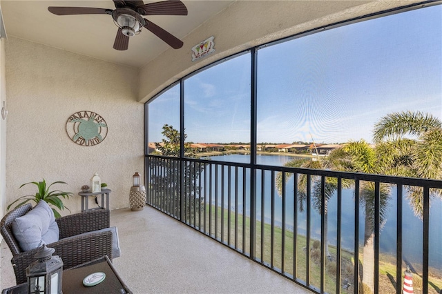 sunroom featuring a water view and ceiling fan