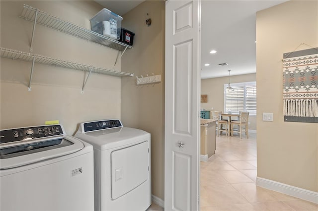 laundry area featuring washing machine and clothes dryer and light tile patterned floors