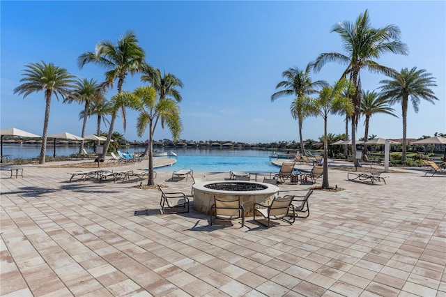 view of pool with a water view, a patio, and a fire pit