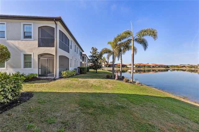 view of yard featuring a water view and central AC unit