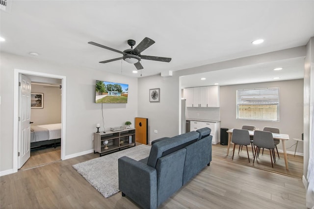 living room featuring ceiling fan and light hardwood / wood-style floors