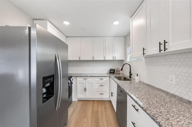 kitchen with white cabinetry, black dishwasher, sink, and stainless steel fridge with ice dispenser