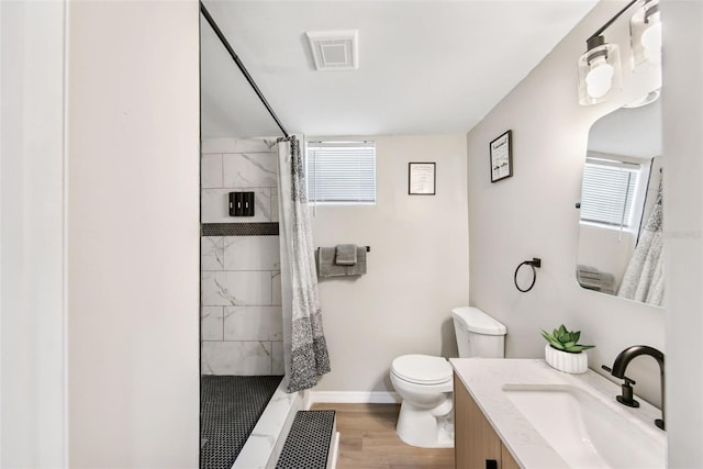 bathroom featuring hardwood / wood-style flooring, vanity, curtained shower, and toilet