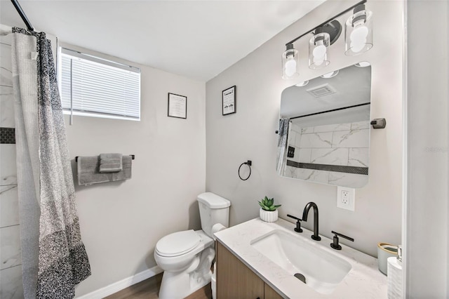 bathroom featuring vanity, toilet, and walk in shower