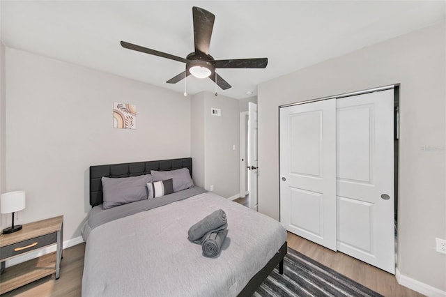 bedroom featuring wood-type flooring, ceiling fan, and a closet