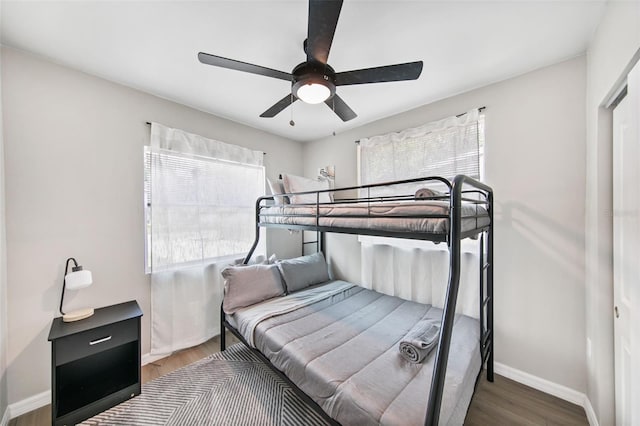 bedroom with multiple windows, hardwood / wood-style floors, and ceiling fan