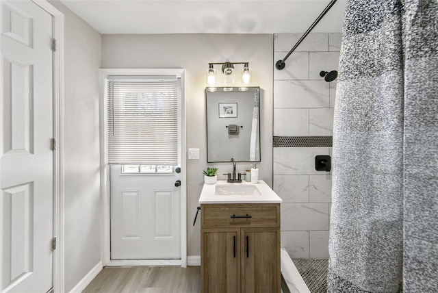 bathroom featuring vanity, tiled shower, and hardwood / wood-style floors