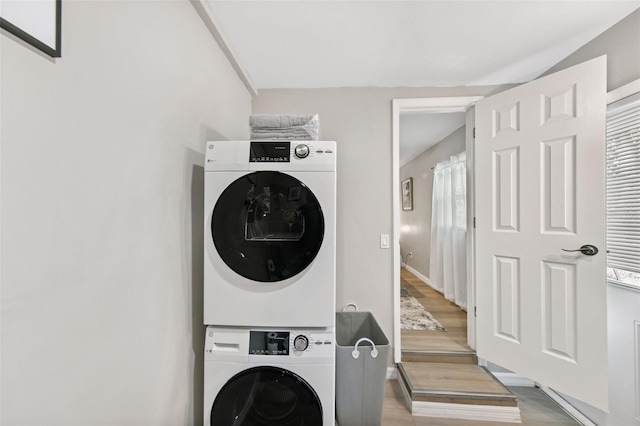 clothes washing area featuring stacked washer / drying machine and light hardwood / wood-style floors