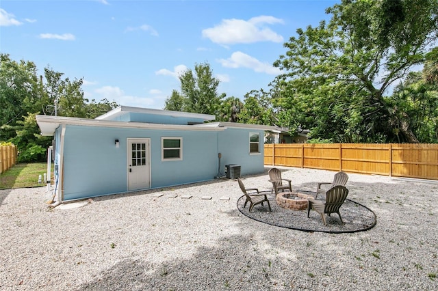 rear view of property with an outdoor fire pit, central AC unit, and a patio