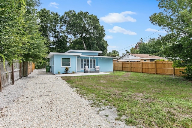 rear view of house featuring a lawn and a patio area