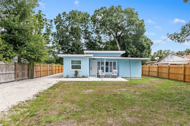 rear view of property featuring a yard and a patio