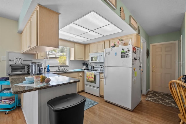 kitchen featuring light brown cabinetry, sink, kitchen peninsula, white appliances, and light hardwood / wood-style flooring