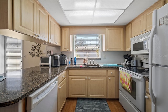 kitchen featuring white appliances, dark stone counters, sink, and light brown cabinets