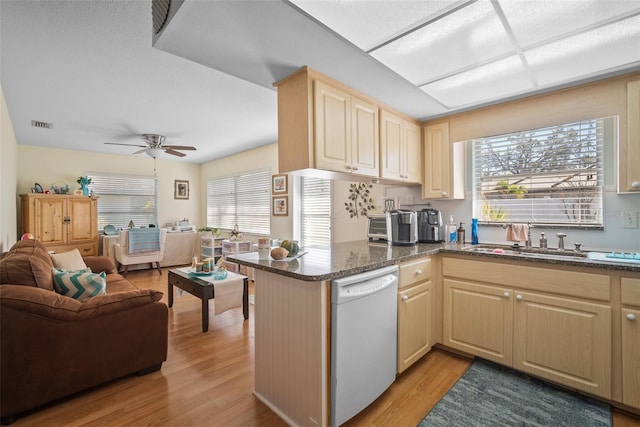 kitchen with dishwasher, sink, kitchen peninsula, and light hardwood / wood-style flooring