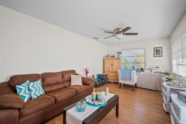 living room with wood-type flooring, a wealth of natural light, and ceiling fan