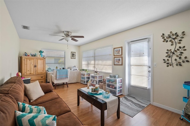 living room with ceiling fan and light hardwood / wood-style floors