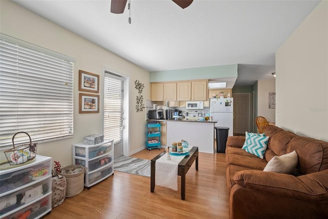 living room featuring ceiling fan and light hardwood / wood-style flooring