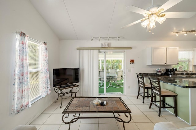 tiled living room with sink, a wealth of natural light, track lighting, and ceiling fan