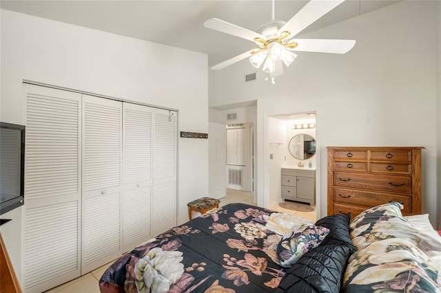 tiled bedroom with ensuite bath, high vaulted ceiling, a closet, and ceiling fan