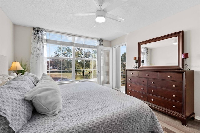 bedroom featuring ceiling fan, light hardwood / wood-style floors, and a textured ceiling