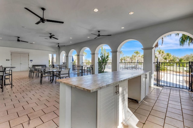 view of patio with ceiling fan and exterior bar