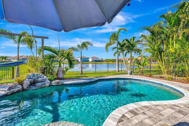 view of swimming pool with a water view, fence, and a fenced in pool