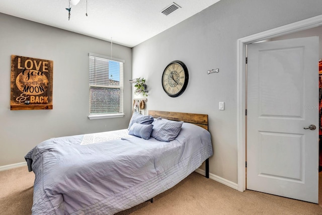 bedroom featuring visible vents, light carpet, and baseboards