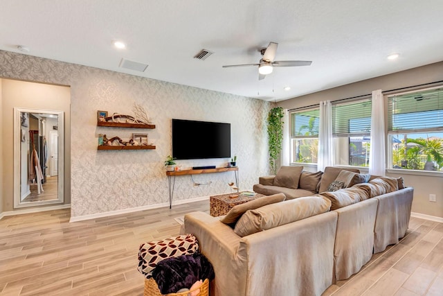 living area featuring wallpapered walls and light wood-style flooring