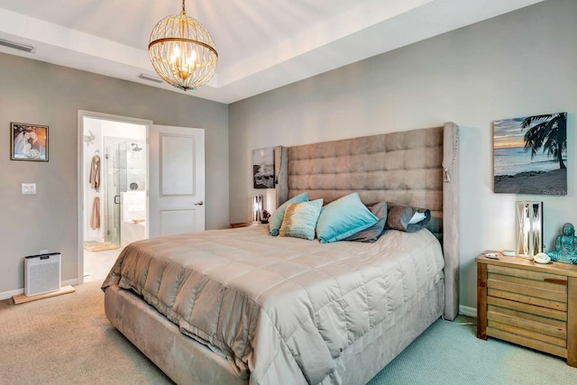 carpeted bedroom featuring baseboards, visible vents, ensuite bath, an inviting chandelier, and a tray ceiling