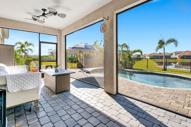 sunroom with a water view and a ceiling fan