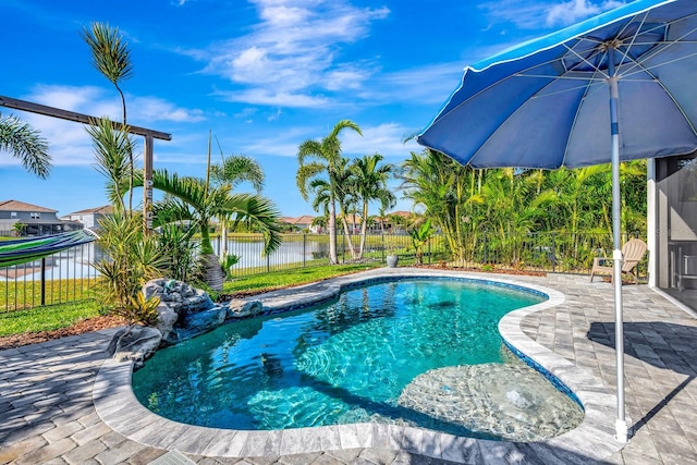 view of swimming pool featuring a patio area, a water view, a fenced backyard, and a fenced in pool