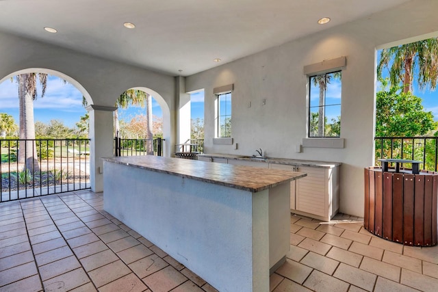 kitchen with light countertops, white cabinetry, a kitchen island, and recessed lighting