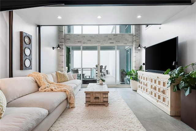 living room with a towering ceiling and concrete floors