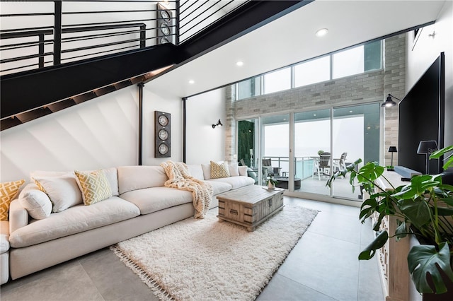 living area with light tile patterned floors, a towering ceiling, and recessed lighting