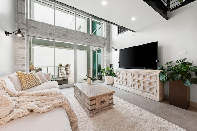 living room featuring a high ceiling, concrete floors, and recessed lighting