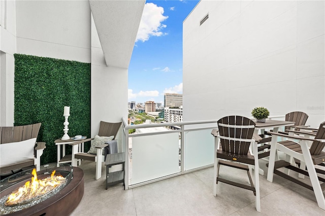 balcony featuring an outdoor fire pit and a view of city