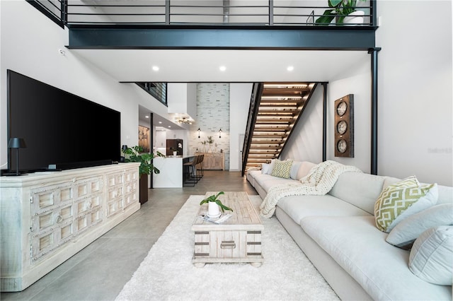 living room with concrete flooring and a towering ceiling