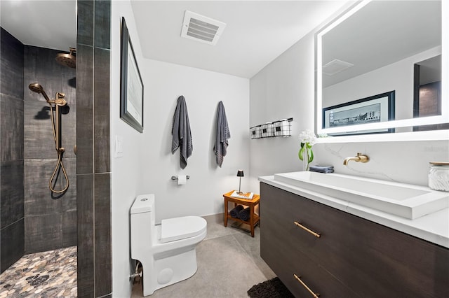 bathroom featuring vanity, toilet, and tiled shower