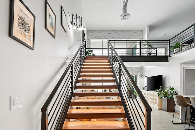 stairway with a towering ceiling and visible vents