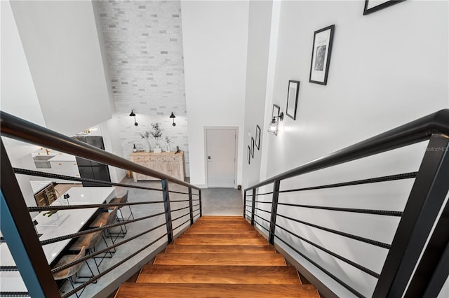 stairway featuring a towering ceiling