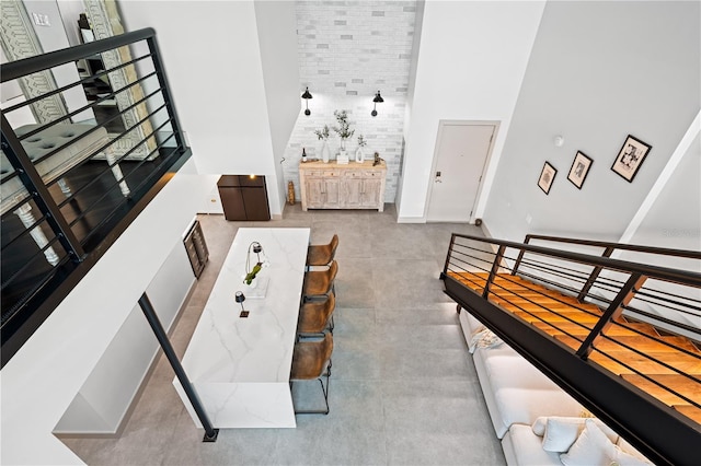 living area featuring concrete floors and a towering ceiling